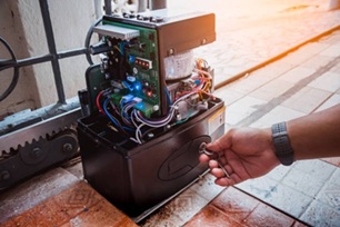 Technicien PROTECFERM en train d'installer une motorisation de portail